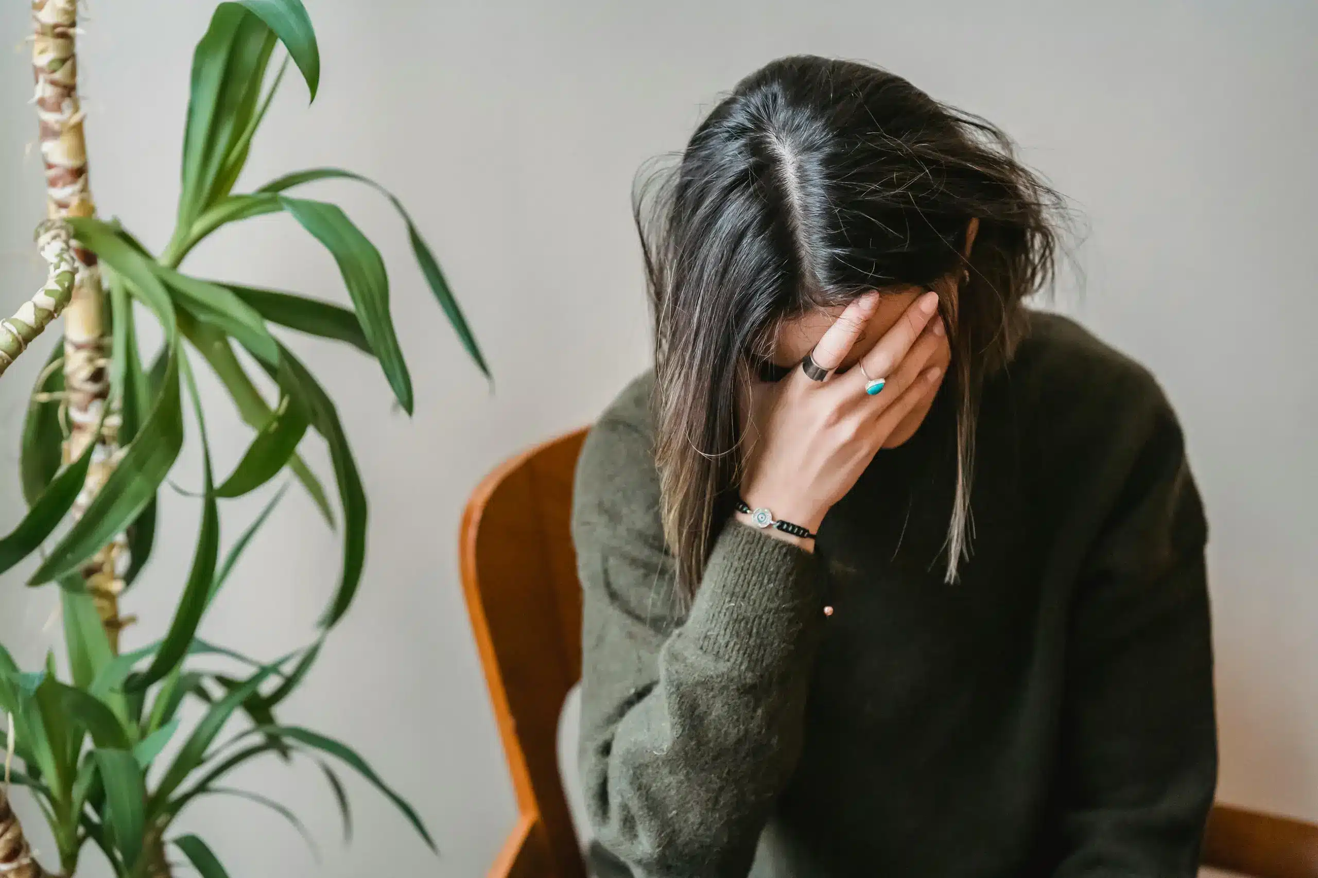 Distressed woman sitting with head in hand, symbolizing emotional struggle—representative of mental health challenges potentially addressed with ketamine for borderline personality disorder.